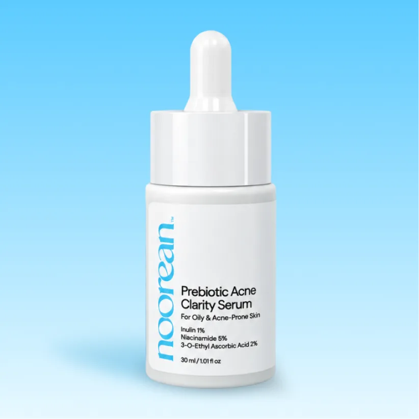 A white dropper bottle of Noorean Prebiotic Acne Clarity Serum against a light blue gradient background.